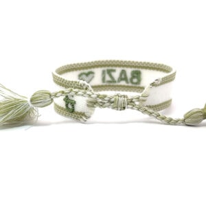 Handgearbeitetes Webarmband aus CANVAS  Baumwolle mit dem Statement Bazi weißes Band mit schlammgrüner Schrift und einem Herzen